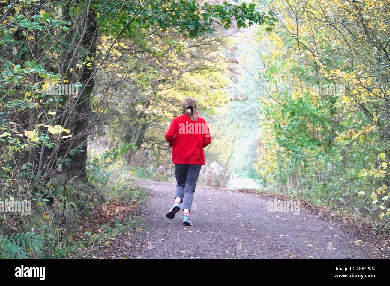 Una ragazza in giacca rossa sul Sett Valley Trail nel Derbyshire Foto Stock