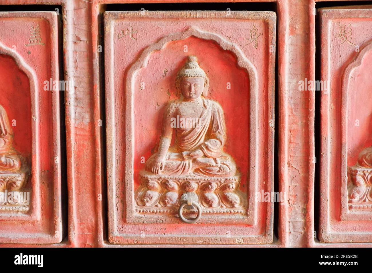 Una statua di pietra di Buddha ha craved sulle pareti rosse nel Tempio di Zhihua, Pechino Foto Stock