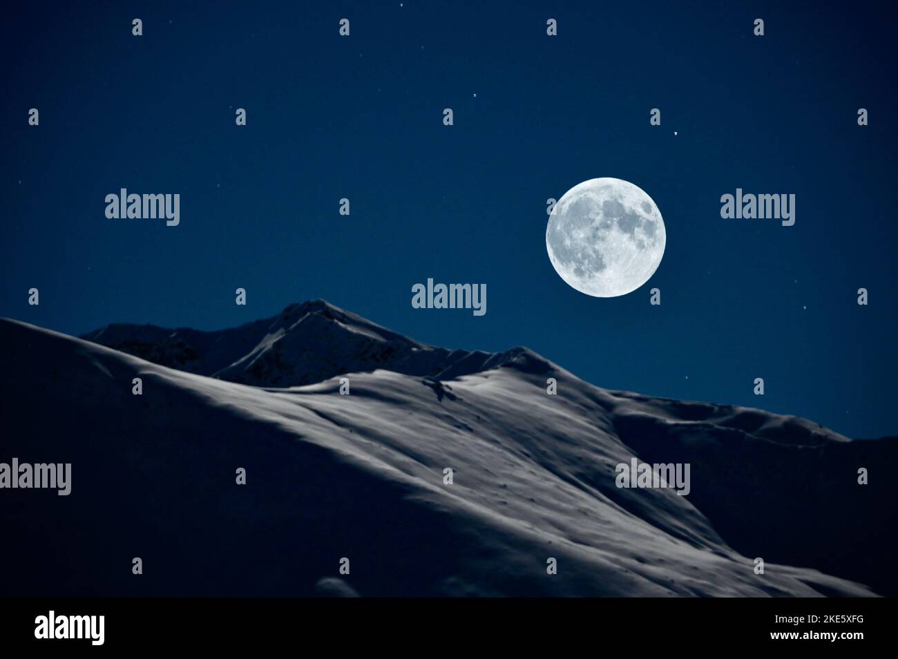 La luna piena che sorge sulla catena montuosa Talkeetna, Hatcher Pass Alaska Foto Stock