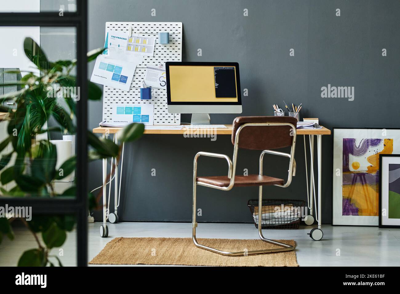 Posto di lavoro di moderno lavoratore colletto bianco o designer creativo con monitor e bacheca con documenti finanziari Foto Stock