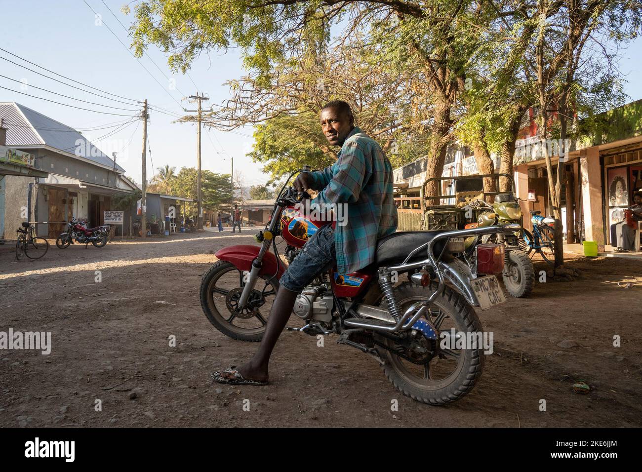 Mtowambu, Tanzania - 12th ottobre 2022: Un motociclista che mostra la sua moto nella strada principale della piccola città di Mtowambu, Tanzania. Foto Stock