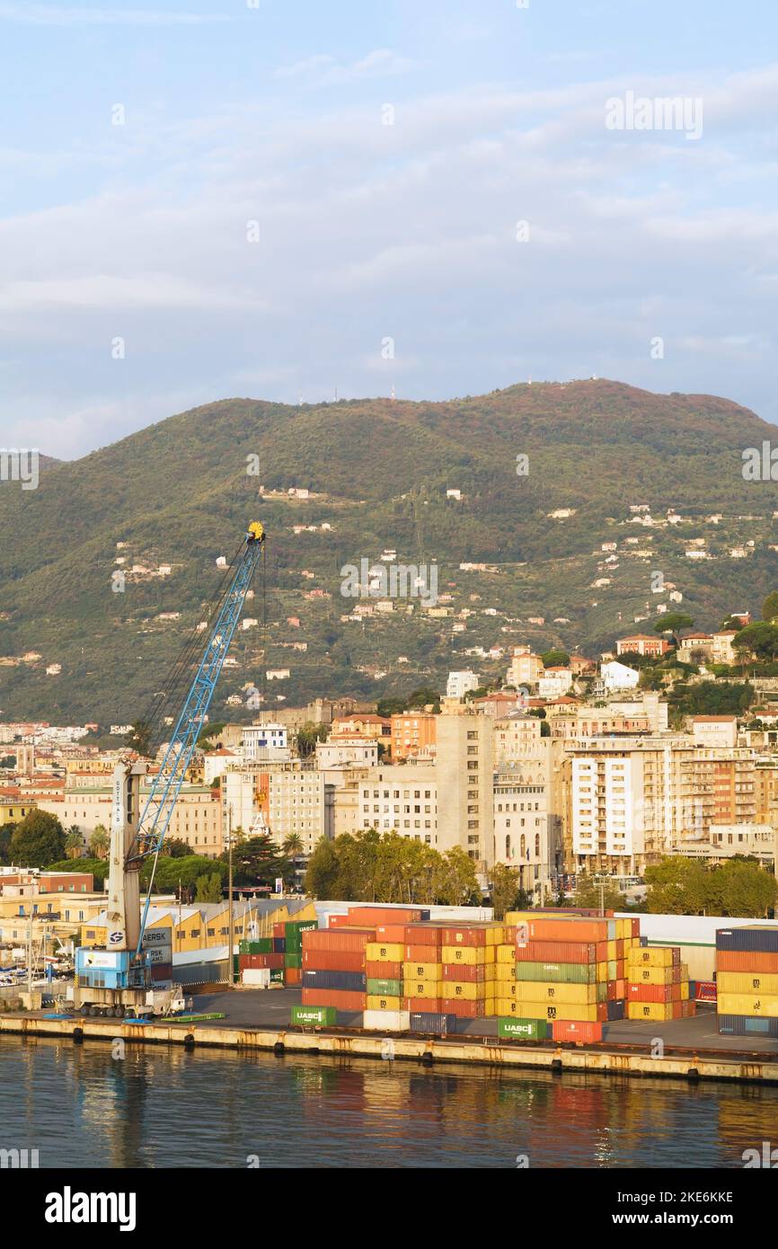 Container impilati e gru a portale blu sul molo del porto commerciale di la Spezia e dello skyline della città, Italia Foto Stock