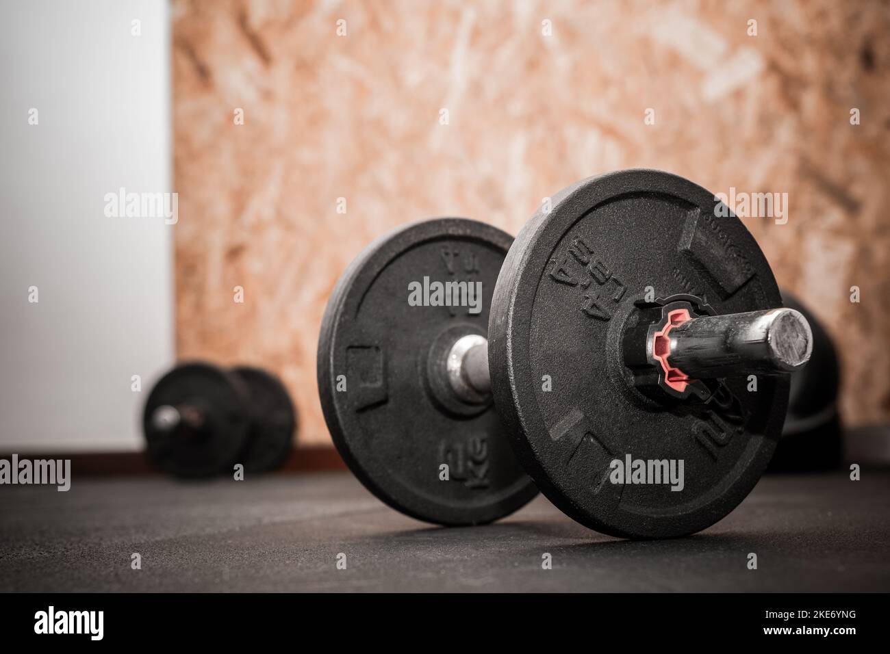 Primo piano di 4,4lbs o 2Kg dumbbell caricabile. Attrezzature per il bodybuilding sul pavimento della palestra con sfondo sfocato e spazio vuoto per il testo Foto Stock