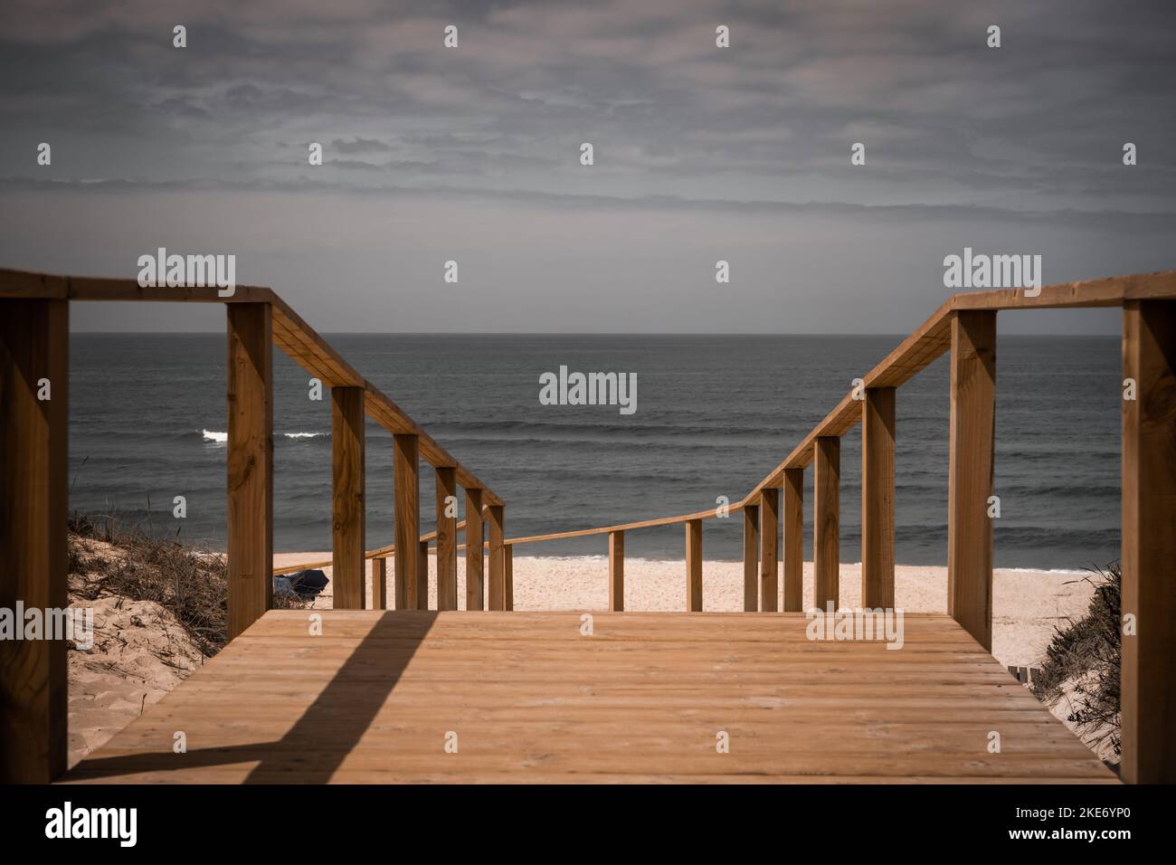Passerella in legno che conduce alla spiaggia e all'Oceano Atlantico. Fotografia di paesaggi a Quiaios Beach in Portogallo in colori desaturati Foto Stock