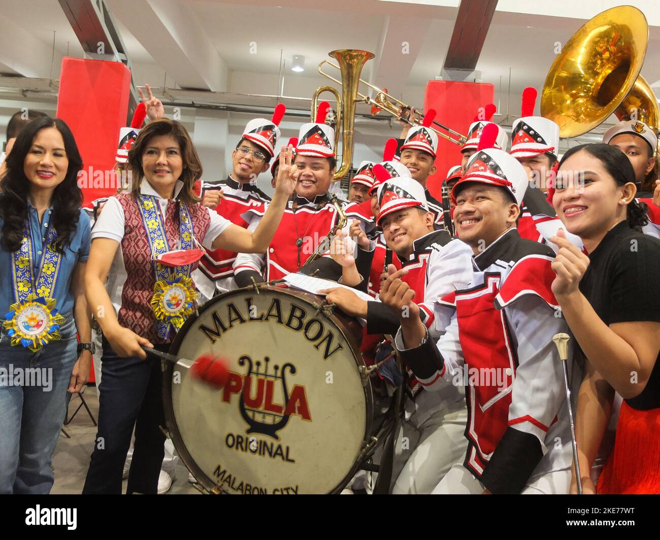 Malabon, Filippine. 10th Nov 2022. Il senatore Imee Marcos (R) insieme al sindaco della città di Malabon Jeannie Sandoval (L) presenta per una foto di gruppo i membri di banda Pula, una band locale in marcia a Malabon City. Il senatore Imee Marcos riceve un caloroso benvenuto dai residenti malaboni mentre guida insieme al sindaco di Malabon Jeannie Sandoval e all'ex rappresentante di Malabon-Navotas Federico 'Ricky' Sandoval la distribuzione e l'assistenza nutribun agli individui (AICS) al complesso sportivo di Oreta a Malabon City. Credit: SOPA Images Limited/Alamy Live News Foto Stock