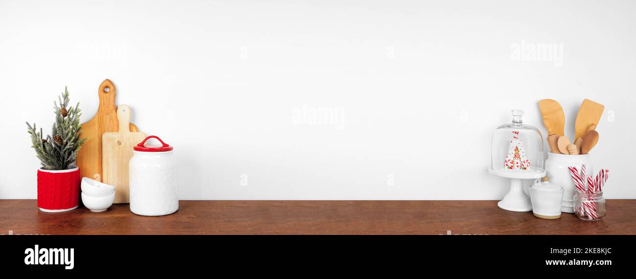 utensili da cucina a tema natalizio, decorazioni e dolci su una mensola o un bancone in legno. Disposizione della cornice su uno sfondo bianco per striscioni a parete con spazio per le copie. Foto Stock
