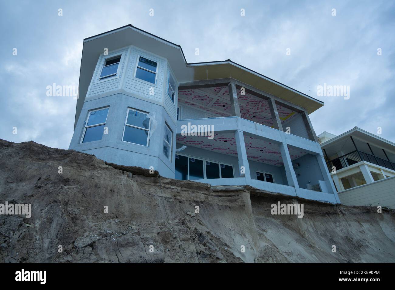 Una casa sulla spiaggia di recente costruzione al 4367 di South Atlantic Avenue si trova precariosamente su una scogliera creata dall'uragano Nicole. 10 Nov 2022. Foto Stock