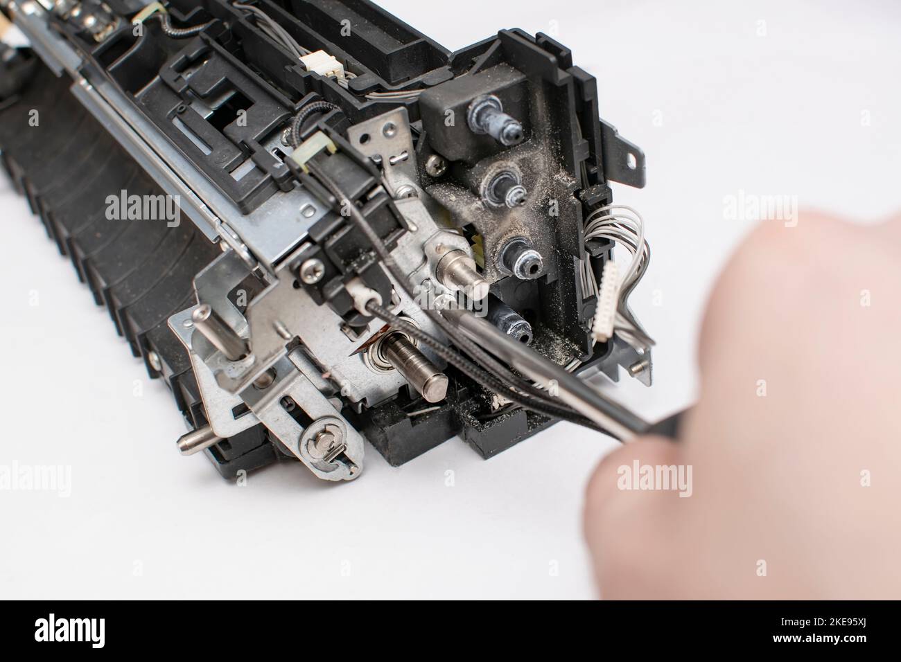 una vista del cambio di un nodo del dispositivo tecnico in cui la mano principale svita un bullone, una vite, un dado con un cacciavite Foto Stock