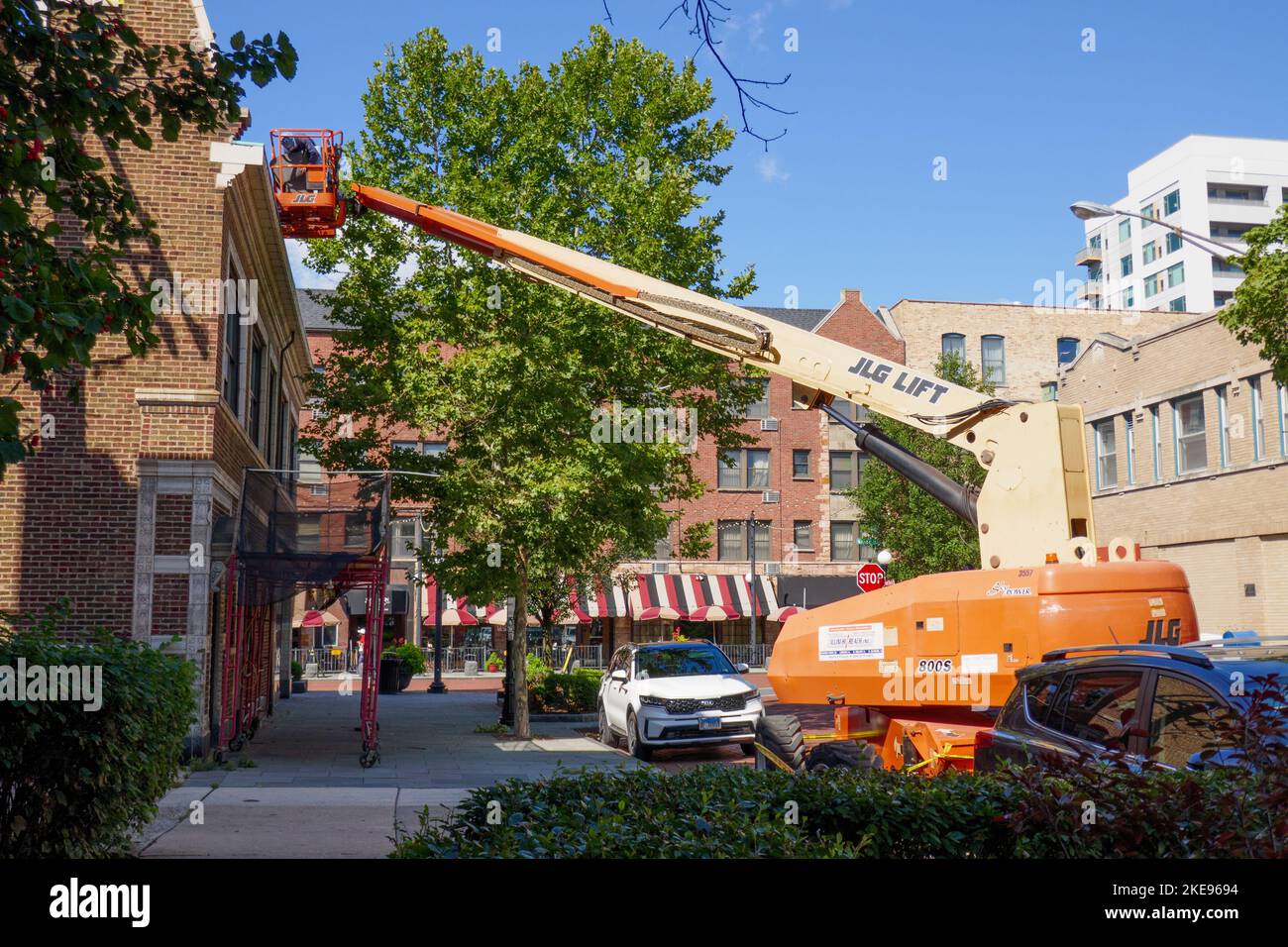 Lavoratore su raccoglitrice ciliegio che fa manutenzione sul tetto. Foto Stock
