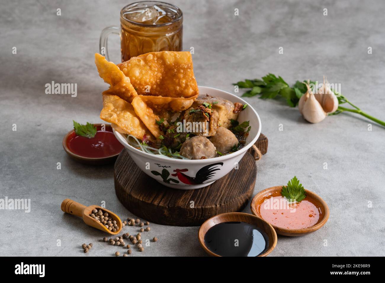 Bakso o polpetta indonesiana servita con zuppa di brodo, tofu, noodle e wonton fritto o gnocchi su un recipiente bianco Foto Stock