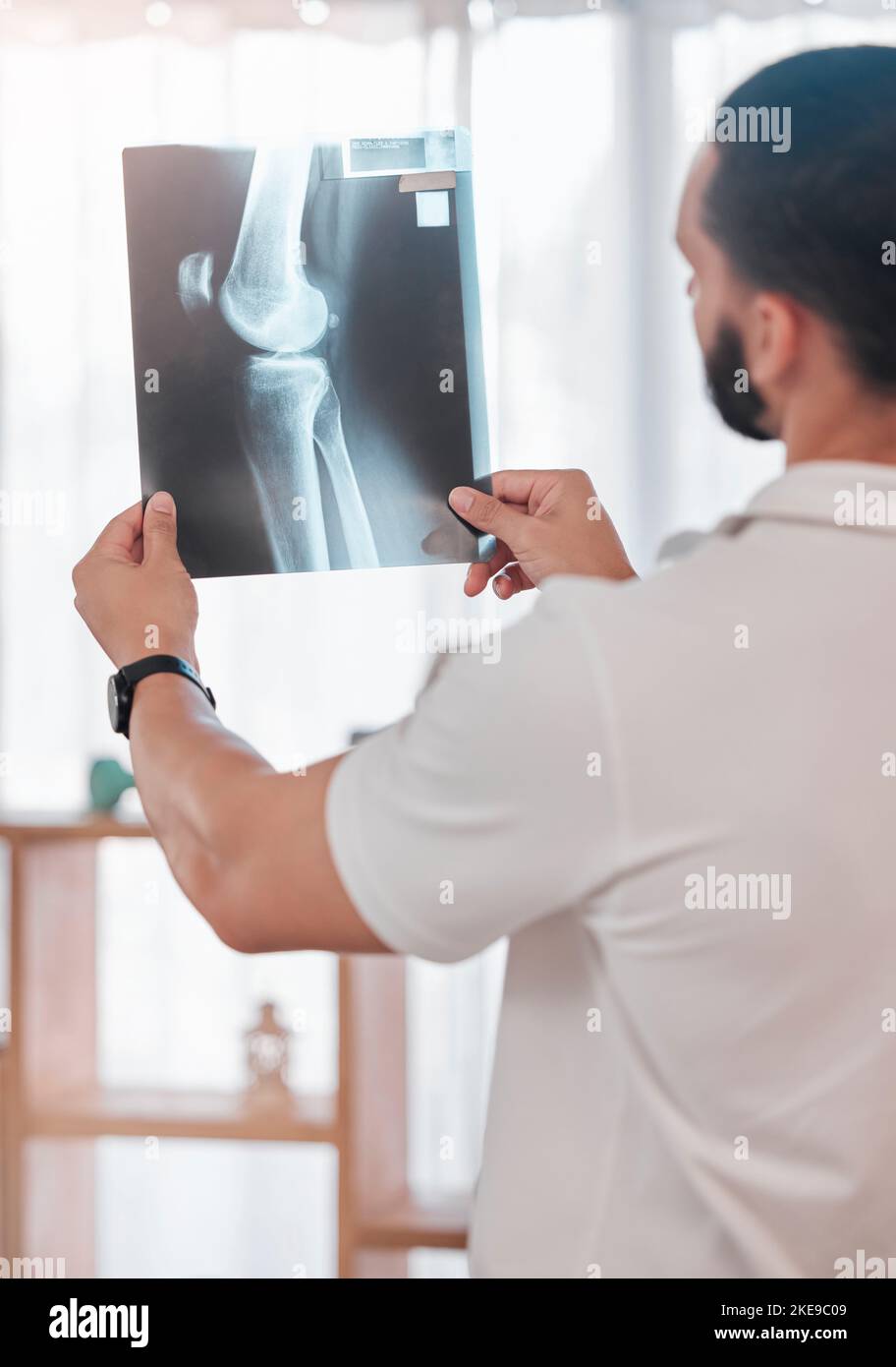Uomo, fisioterapista e analisi radiografica in clinica sportiva per il controllo delle ossa rotte, il benessere sanitario o la pianificazione chirurgica delle lesioni al ginocchio. Medico Foto Stock