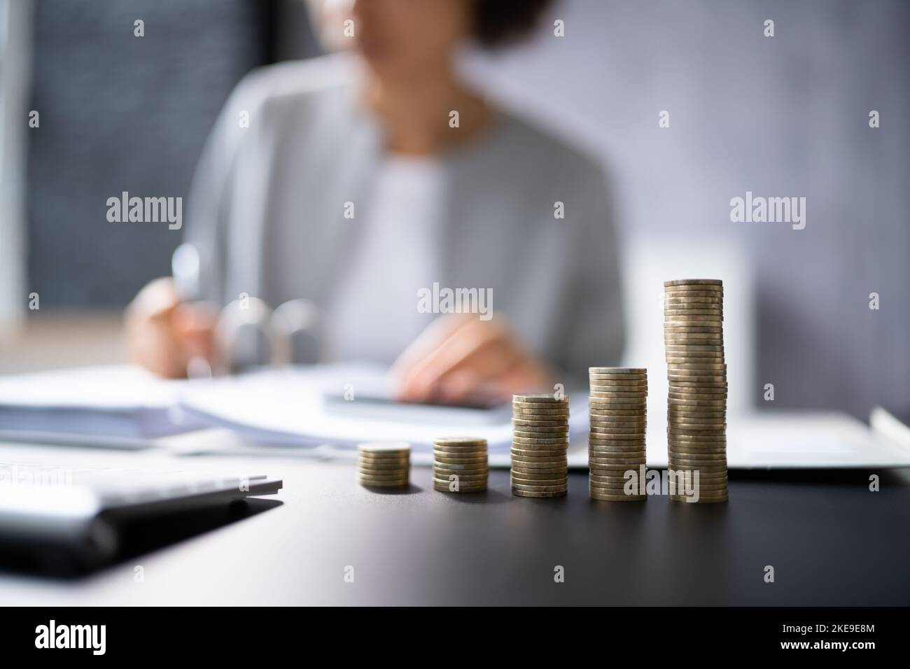 African Accountant Using Calculator. Soldi e monete fiscali Foto Stock