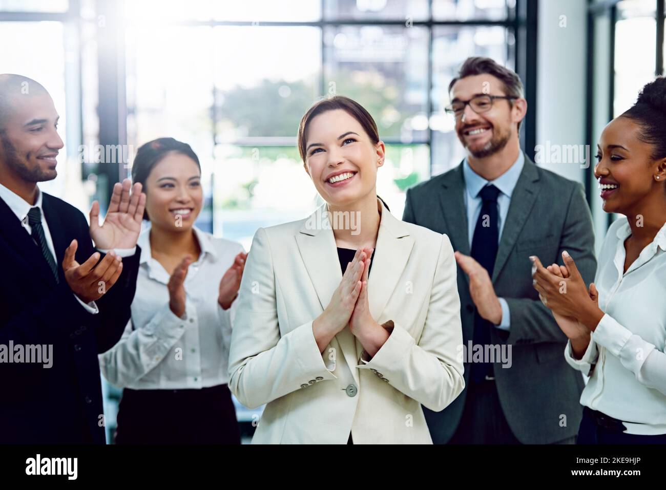 Ben fatto, lei lo merita: Una donna d'affari di successo che viene applaudita dai suoi colleghi in carica. Foto Stock