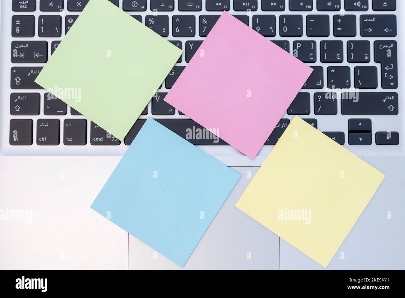 Appunti post adesivi vuoti incollati sulla tastiera del computer portatile. Vista dall'alto Workspace Concept. Foto Stock
