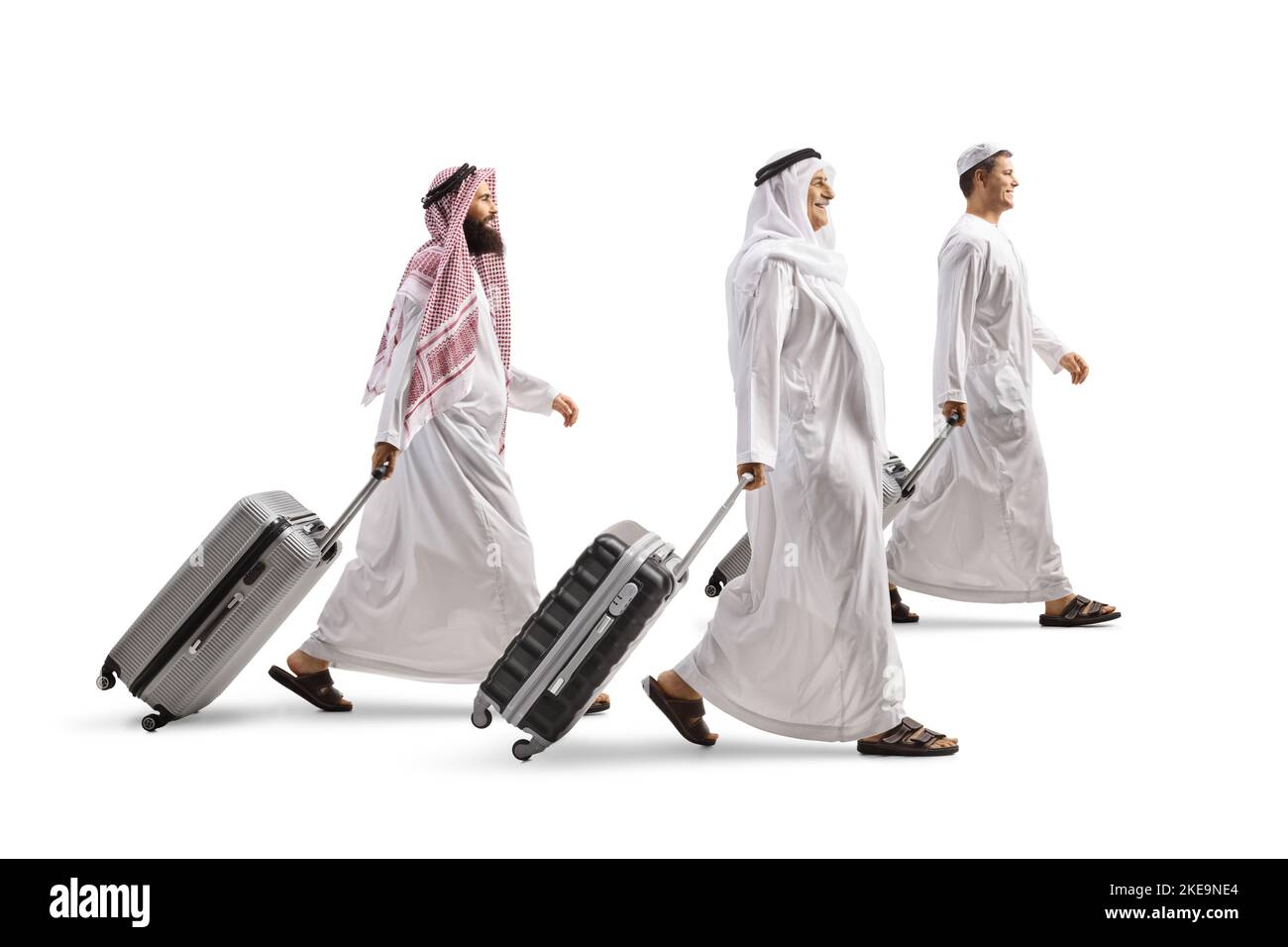 Uomini in abiti etnici arabi camminare e tirare valigie isolate su sfondo bianco Foto Stock