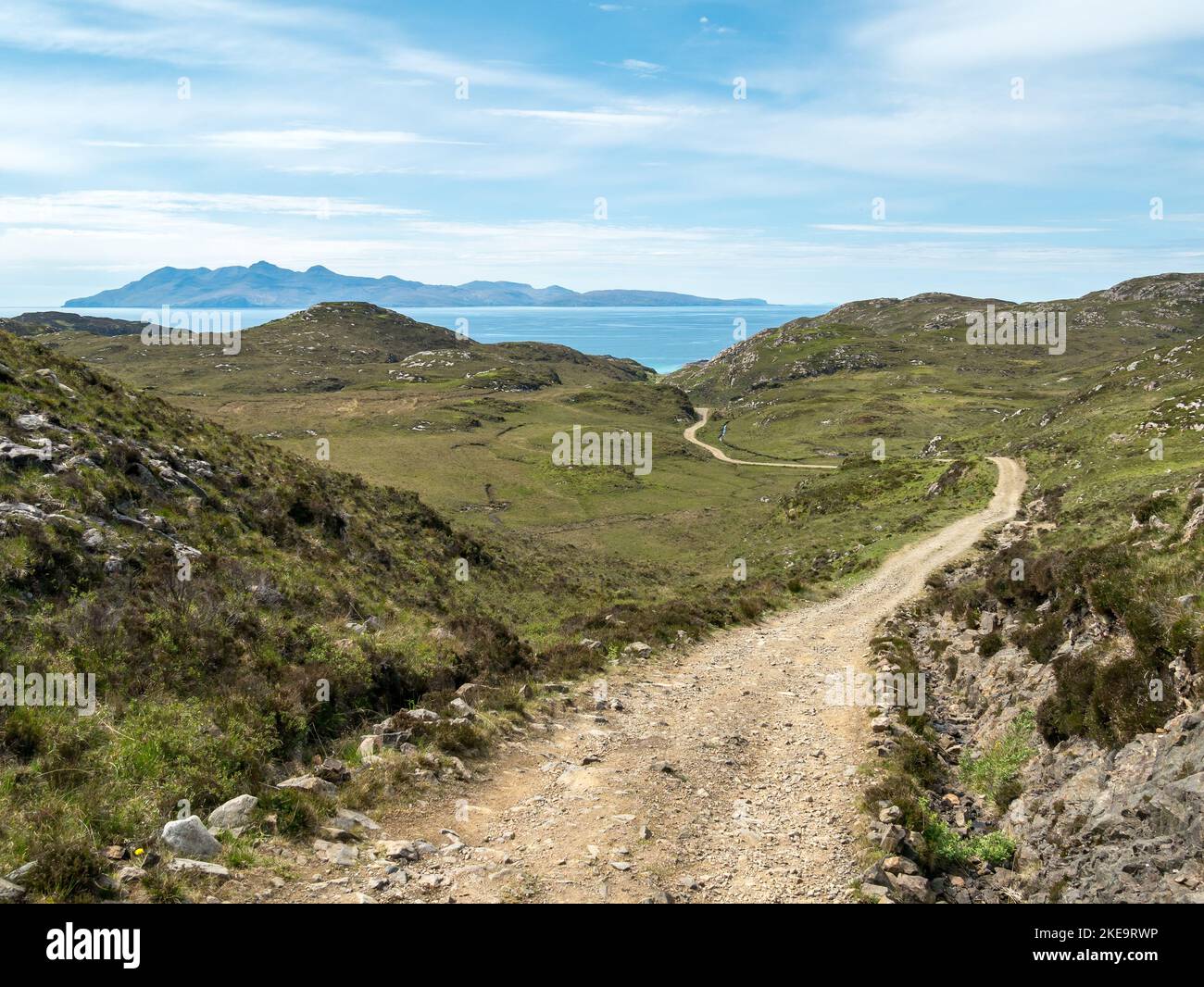 Lungo, accidentato, unico percorso agricolo / strada che conduce al Point of Sleat sull'Isola di Skye con l'Isola scozzese di Rum all'orizzonte, Scozia, Regno Unito Foto Stock