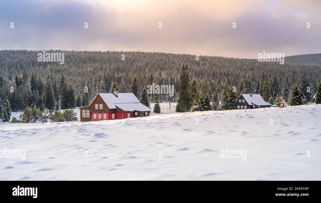 Paesaggio invernale dei Monti Jizera. Prati innevati e vecchia casa di legno nella fredda giornata invernale. Jizerka, Repubblica Ceca. Foto Stock