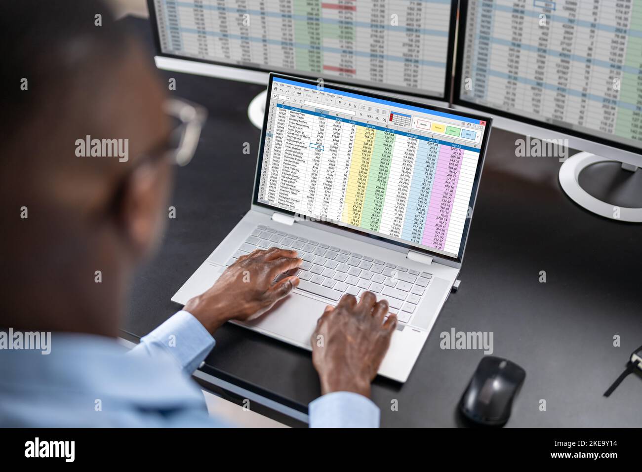 L'analista di dati African Man utilizza un foglio di calcolo sul computer Foto Stock