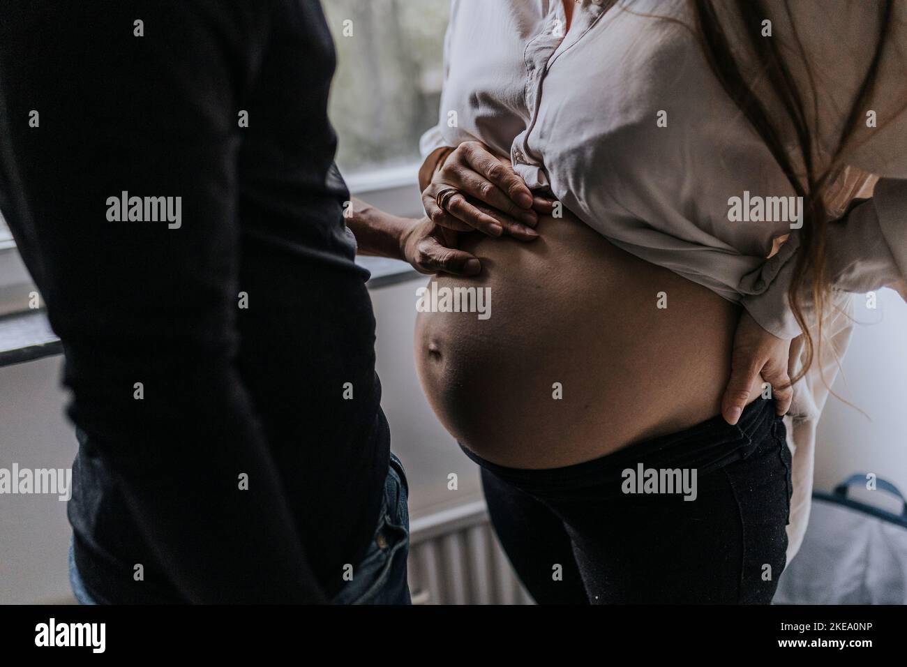 Donna incinta con partner in piedi insieme Foto Stock