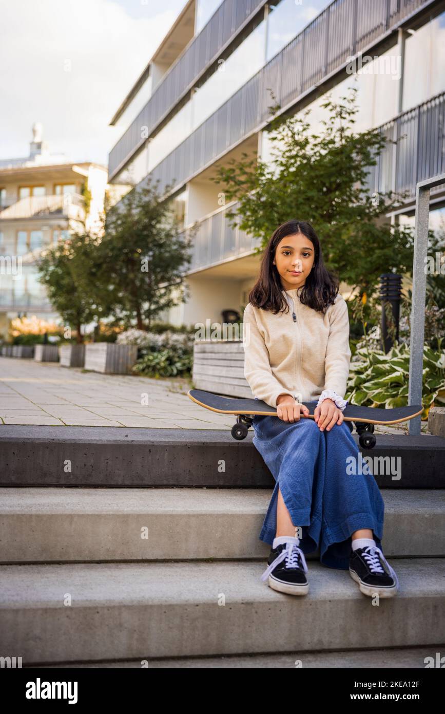 Ritratto di ragazza che tiene skateboard Foto Stock