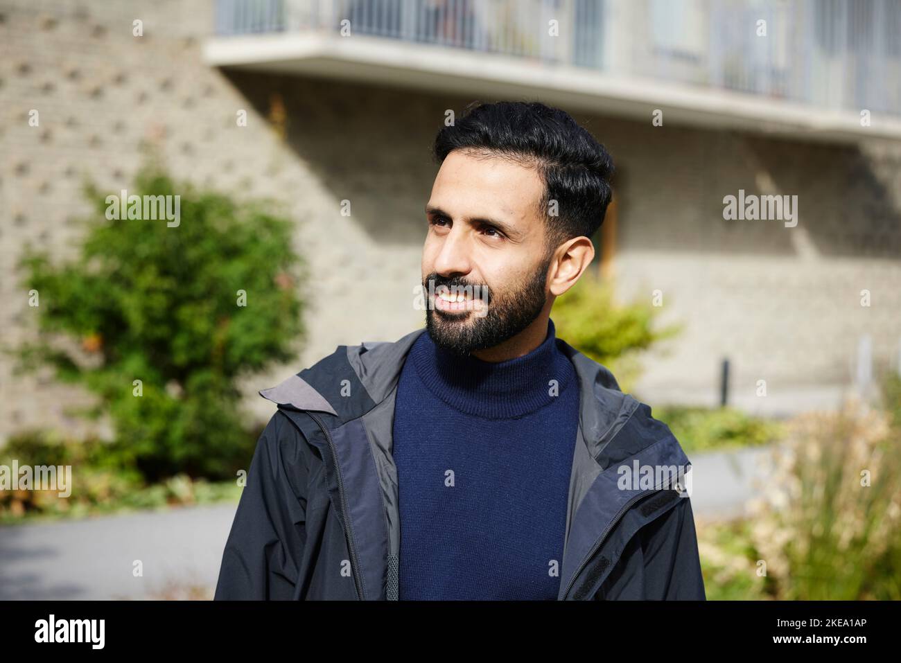 Uomo sorridente che guarda lontano Foto Stock