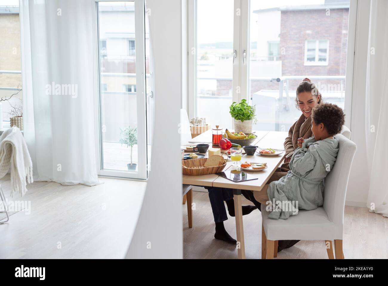 La famiglia si siede al tavolo e mangia la colazione Foto Stock