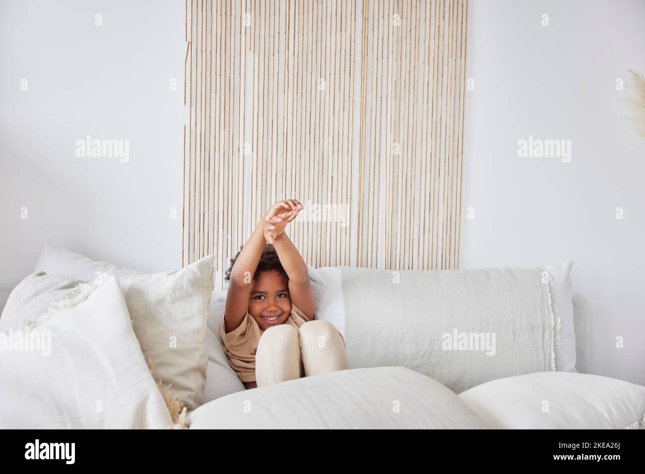 Ragazzo seduto sul divano e sorridente Foto Stock