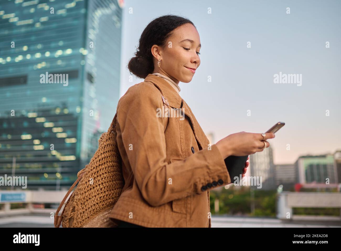 Donna nera, smartphone e outdoor per la comunicazione, la ricerca in Internet e la navigazione online. Ragazza afro-americana, giovane donna e in città con Foto Stock