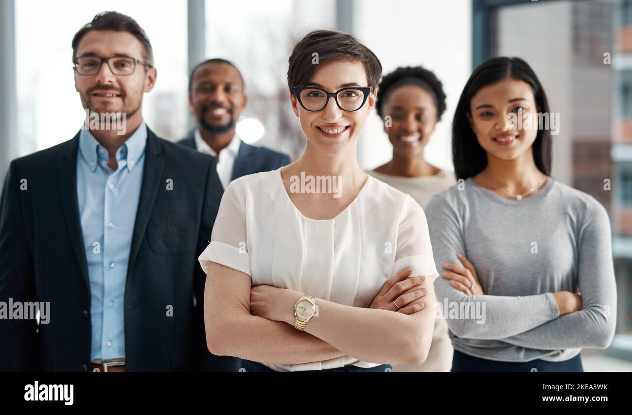 Ognuno di noi ha un ruolo prezioso nel nostro team. Ritratto di un team eterogeneo di professionisti in piedi insieme in un ufficio. Foto Stock