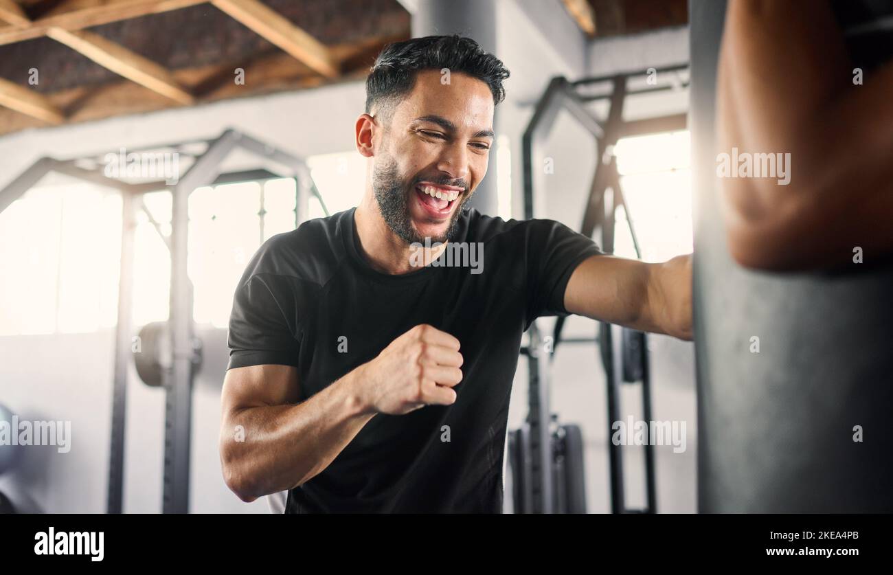 Pugilato palestra, fitness e pugile felice atleta pugilato una borsa da training in uno studio di arti marziali o club. Felicità di un uomo in un allenamento di lotta e sport Foto Stock