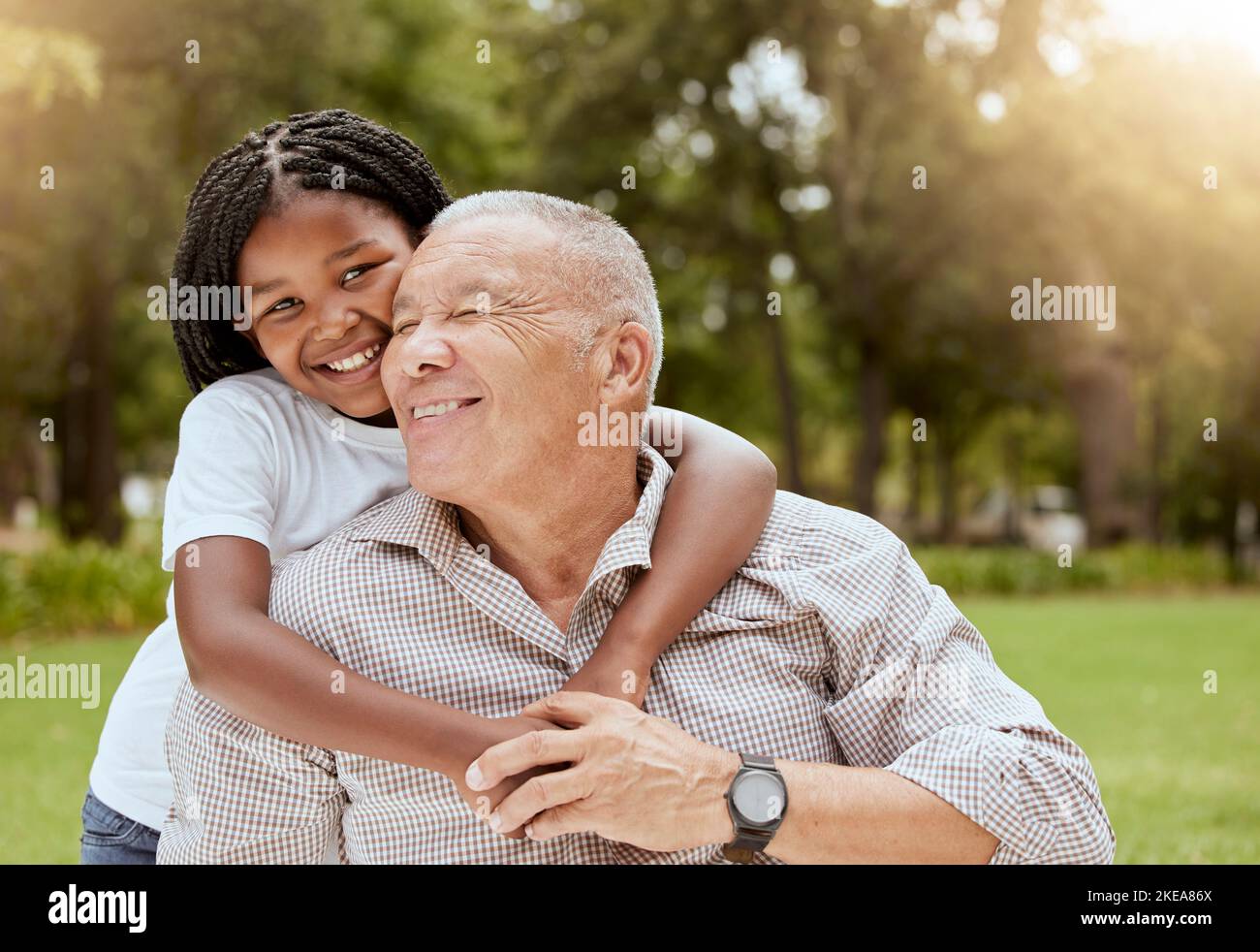 Uomo maturo, amore e abbraccio bambino in natura con nonno e nipote con essere amorevole, la cura con affetto fuori. Vecchio, bambina e. Foto Stock