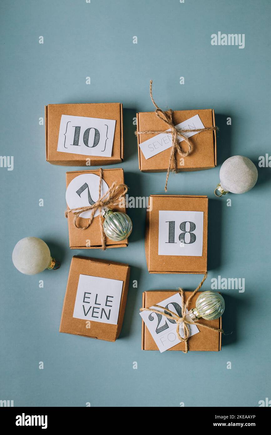 Calendario originale dell'avvento natalizio per i bambini. Regali per i bambini divertimento in carta eco regalo boxex. Vista dall'alto, disposizione piatta. Foto Stock