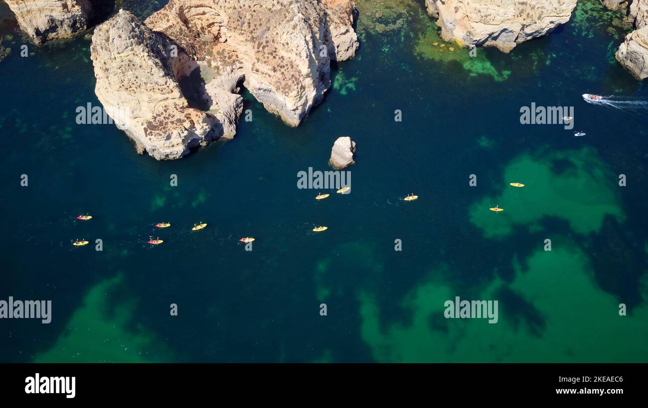 Vista aerea dei droni di barche e kayak nell'Oceano Atlantico, Lagos, Algarve, Portogallo. Esplorazione di grotte e tunnel. Viaggi e avventura. Vacanze. Foto Stock