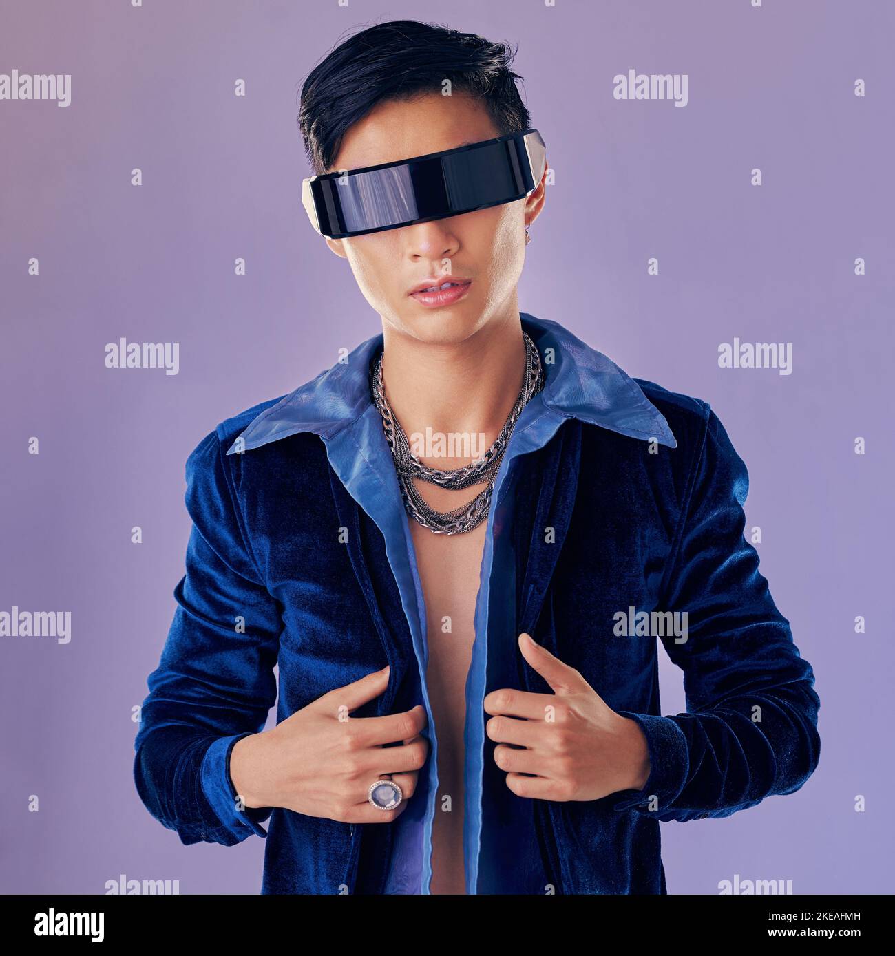 Asiatico, uomo e realtà virtuale con futuri occhiali in studio per estetica, gioielli o cyberpunk da parete lavanda. Modello di moda futuristico, metaverse e metal Foto Stock