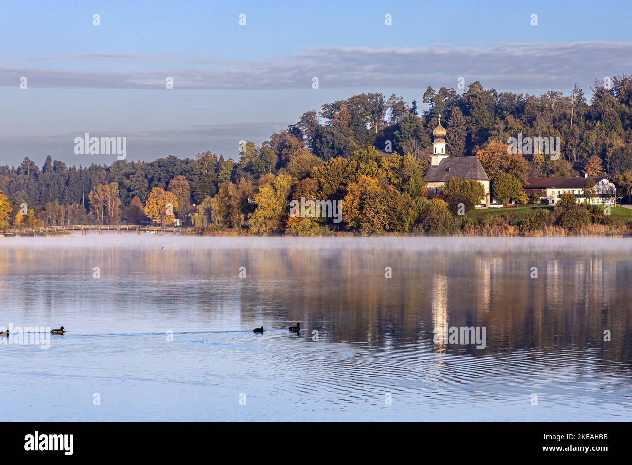 Piccola chiesa nella foresta autunnale sulla riva del lago, Germania, Baviera, Seeoner See, Seeon Foto Stock