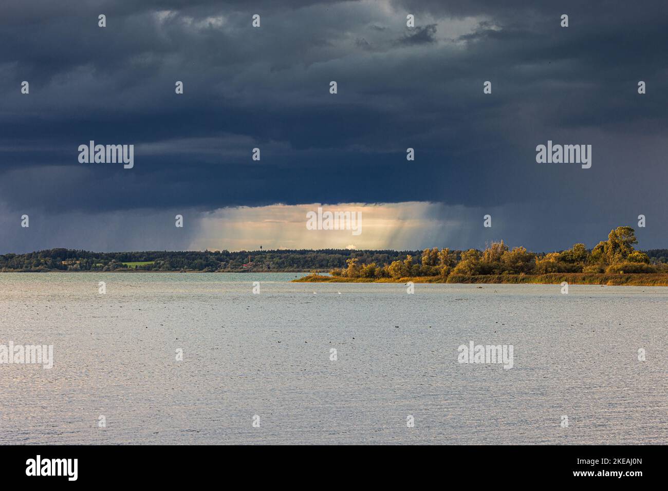 il sole si rompe tra le nuvole durante la tempesta con forte pioggia, Germania, Baviera, Lago di Chiemsee Foto Stock