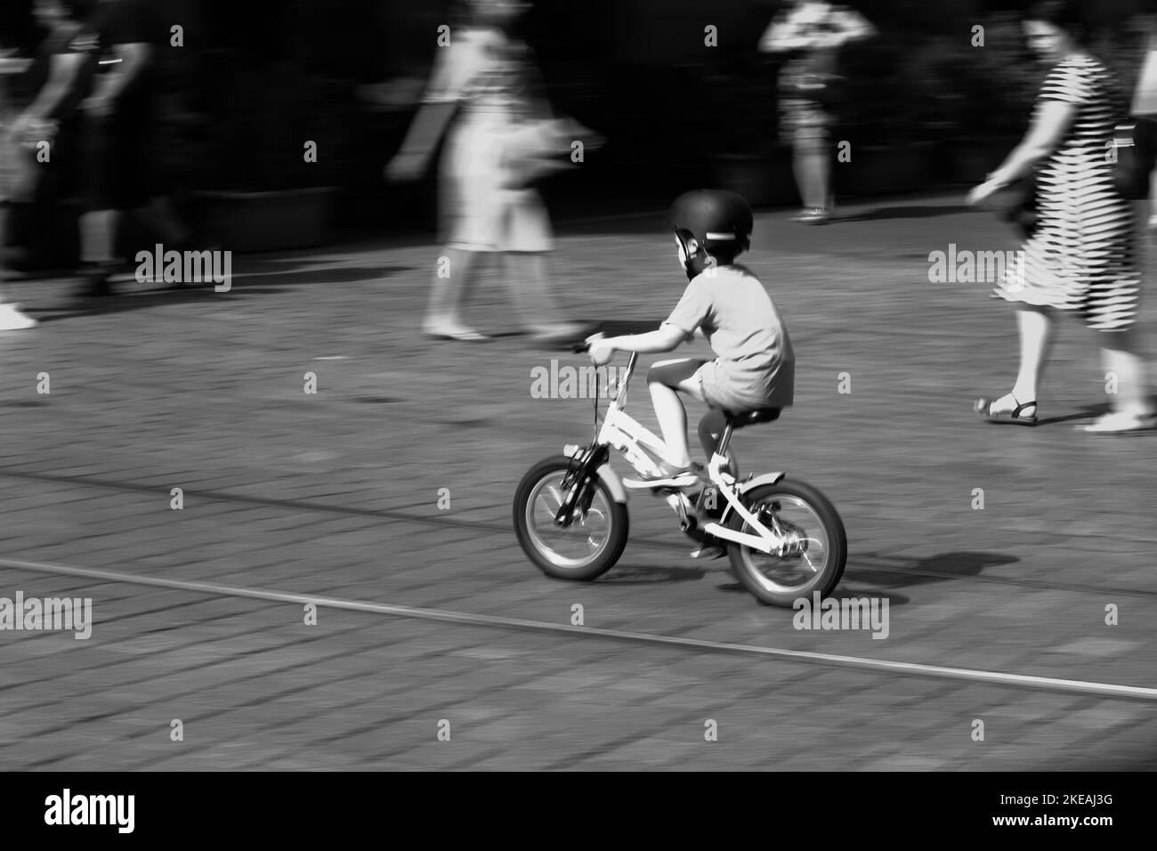 Un bianco e nero di un bambino in bicicletta. Foto Stock