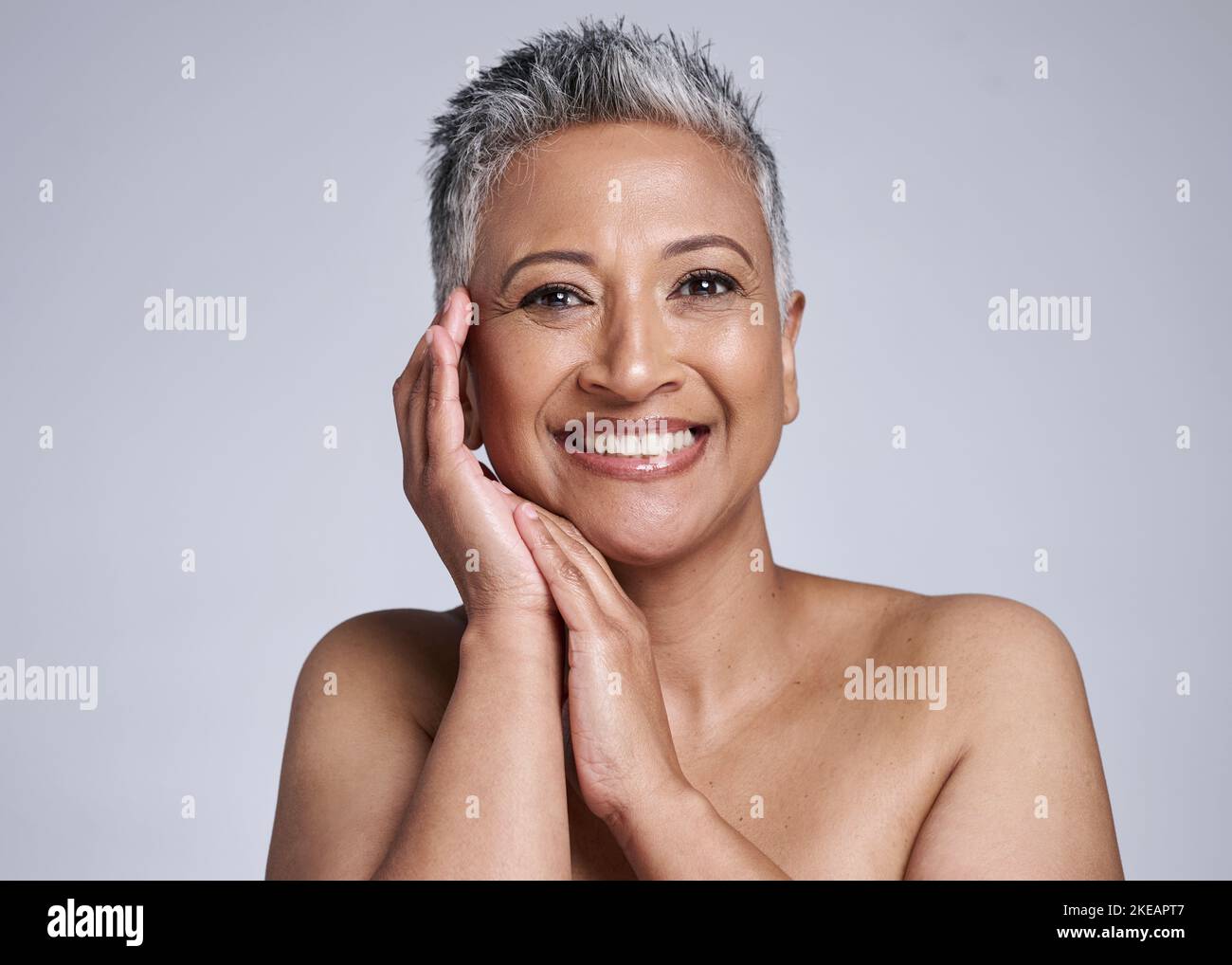 Ritratto, bellezza e sana cura della pelle per la donna matura e felice con trattamenti dermatologici cosmetici su uno sfondo grigio studio. Pelle sana e. Foto Stock