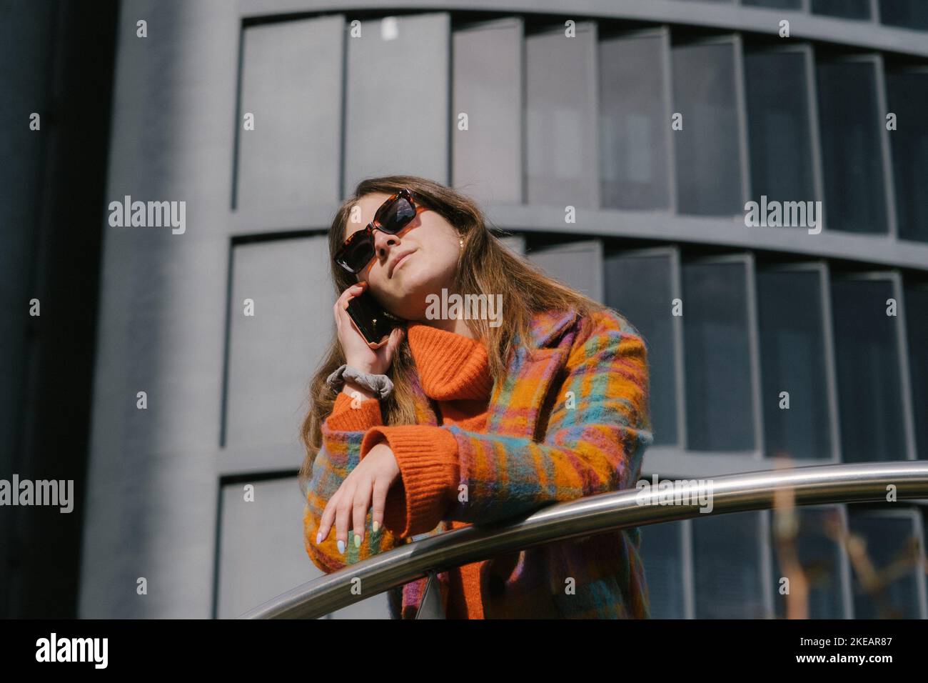 Dirigenti che lavorano con un telefono cellulare per la strada con edifici per uffici in background Foto Stock