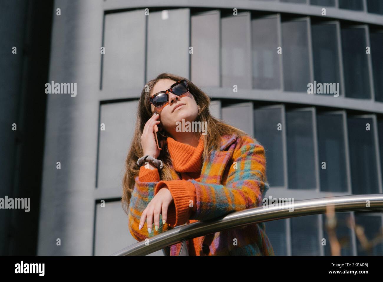 Dirigenti che lavorano con un telefono cellulare per la strada con edifici per uffici in background Foto Stock