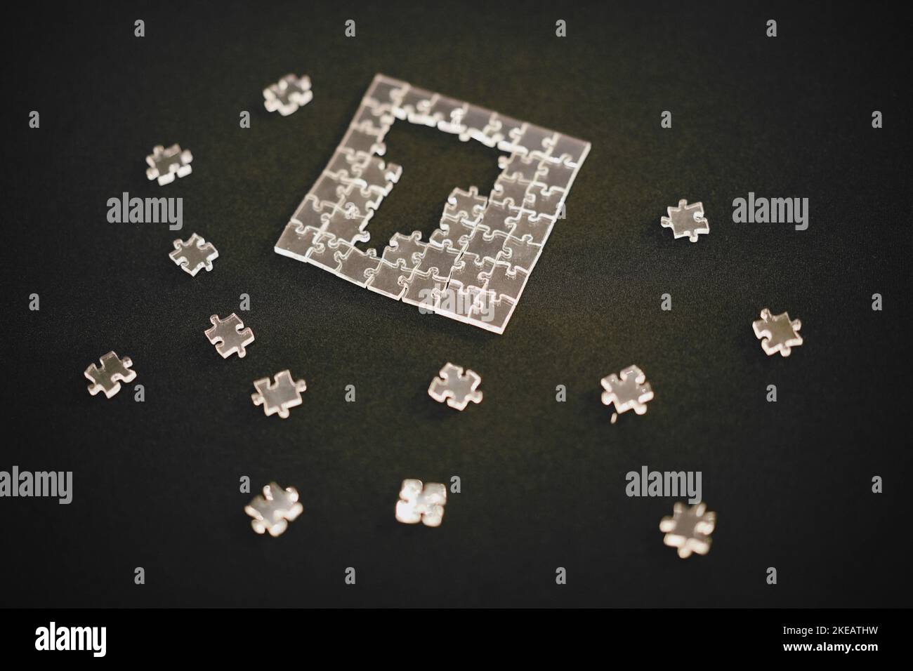Primo piano di un puzzle con pezzi trasparenti. Foto Stock