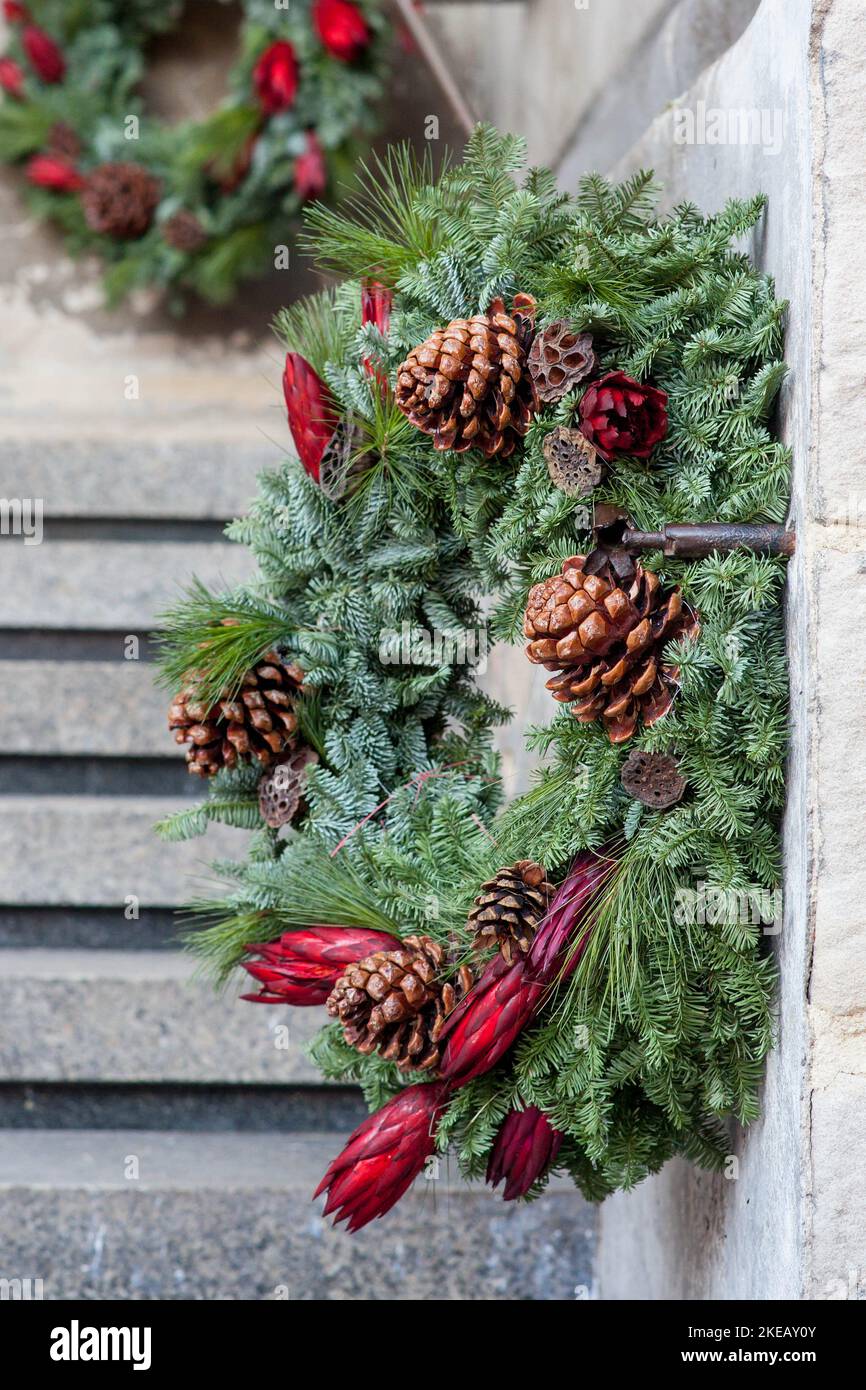 inverno corona di natale decorata da fiori naturali, piante e coni Foto Stock