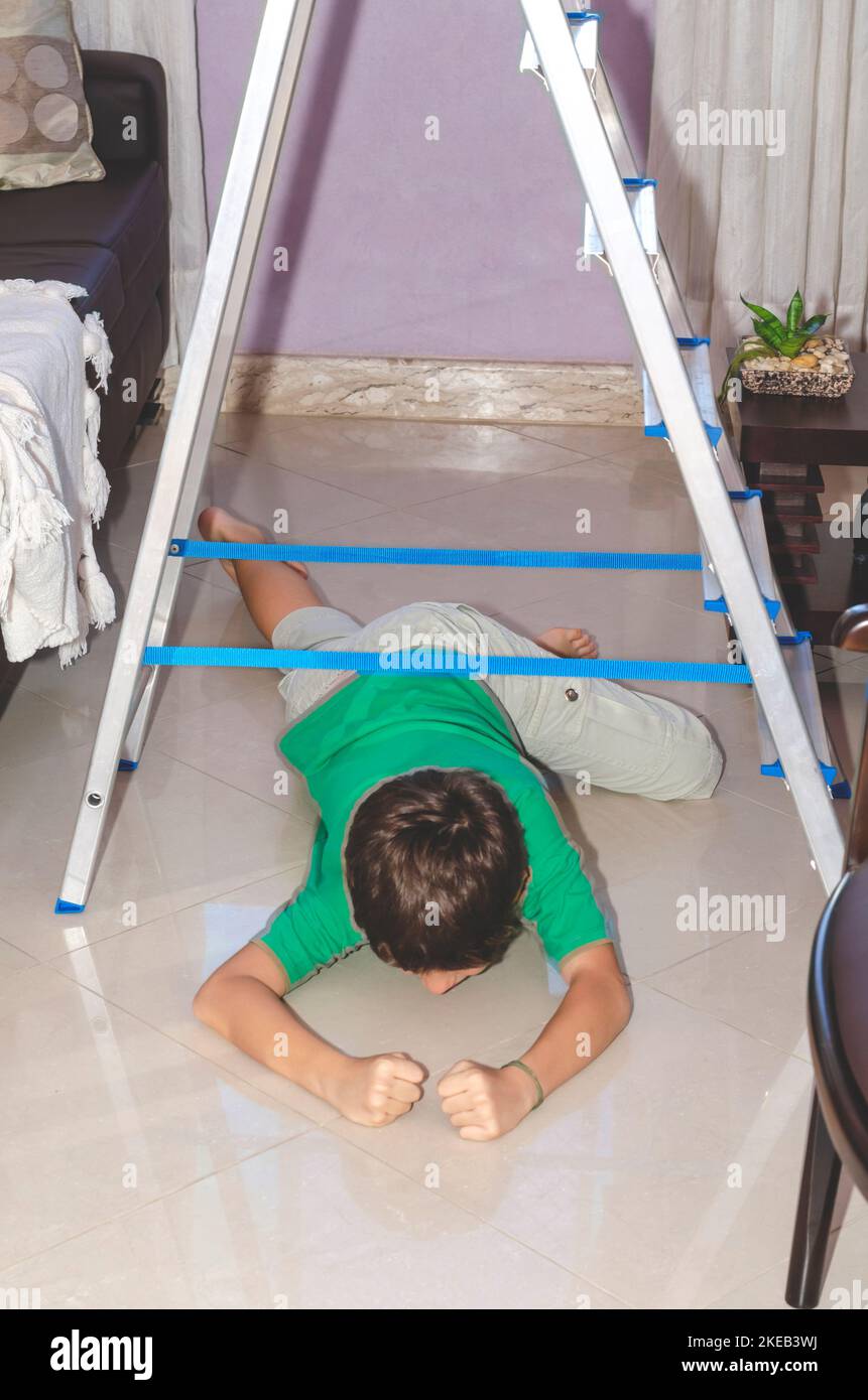 Ritratto di un bambino che gioca al piano di sotto su una scala. Abilità a casa. Salvador, Bahia, Brasile. Foto Stock