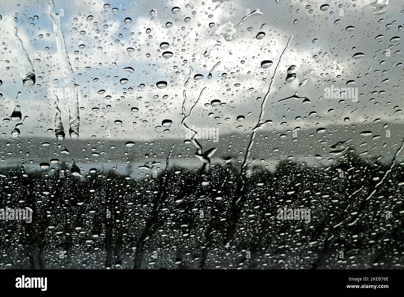 Una vista della pioggia sul parabrezza di un'auto durante una doccia che si affaccia Loch Tuath verso Ulva sulla costa occidentale dell'Isola di Mull, Scozia. Foto Stock