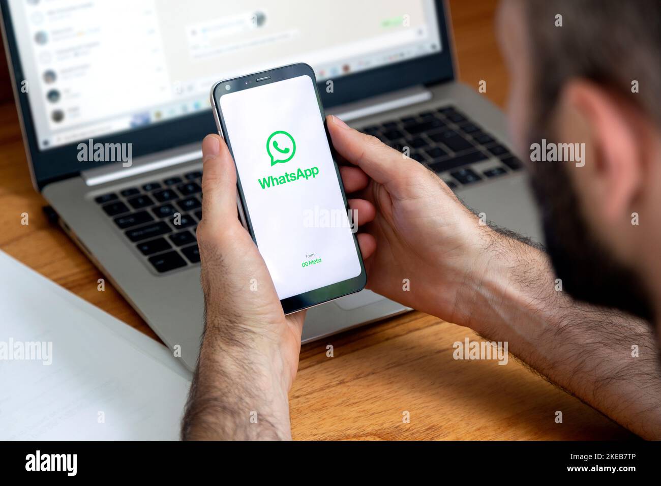 Logo dell'app WhatsApp sullo schermo del telefono in mano a un uomo. Smartphone con display su sfondo bianco e logo verde. Foto Stock