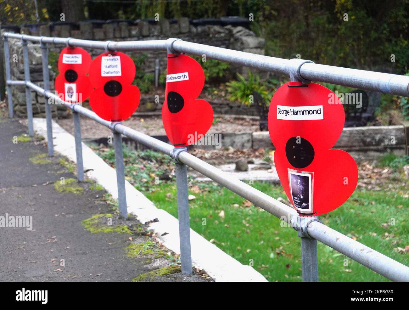 Papaveri su una ringhiera a New Mills, Derbyshire con i nomi di coloro che sono morti in guerre. Foto Stock