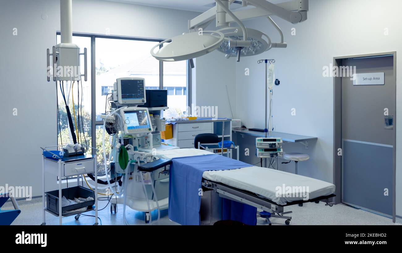 Apparecchiature mediche, tecnologia e illuminazione sul tavolo operatorio in una sala operatoria vuota dell'ospedale Foto Stock