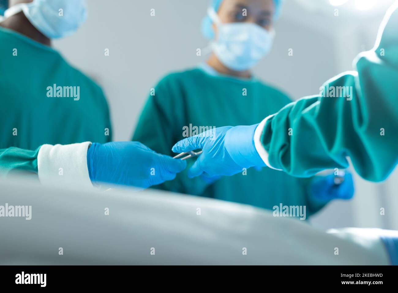 Basso angolo di passaggio degli strumenti chirurgici nella sala operatoria durante il funzionamento, con spazio di copia Foto Stock