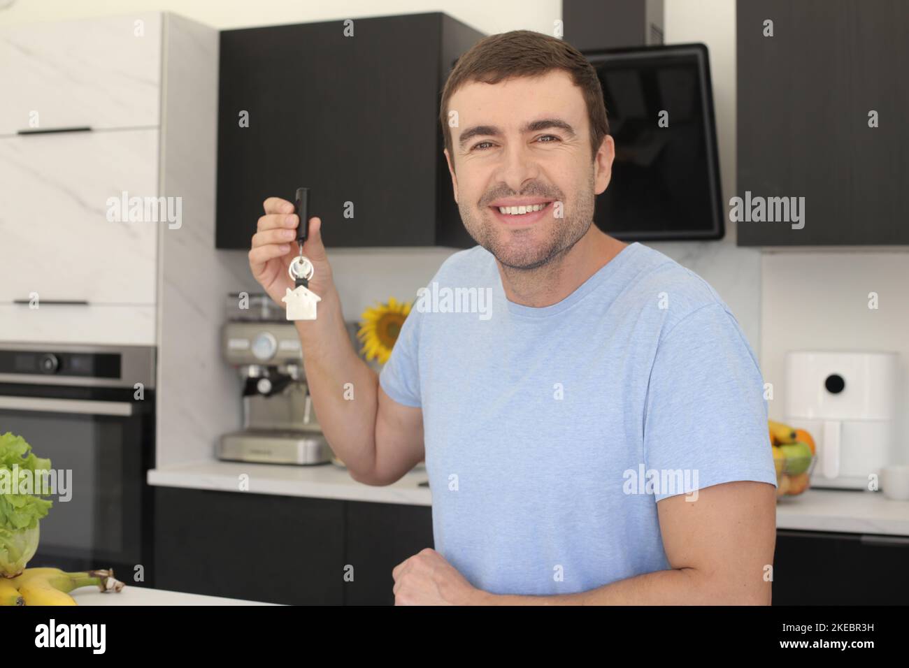 Un uomo eccitato che tiene le sue nuove chiavi di casa Foto Stock