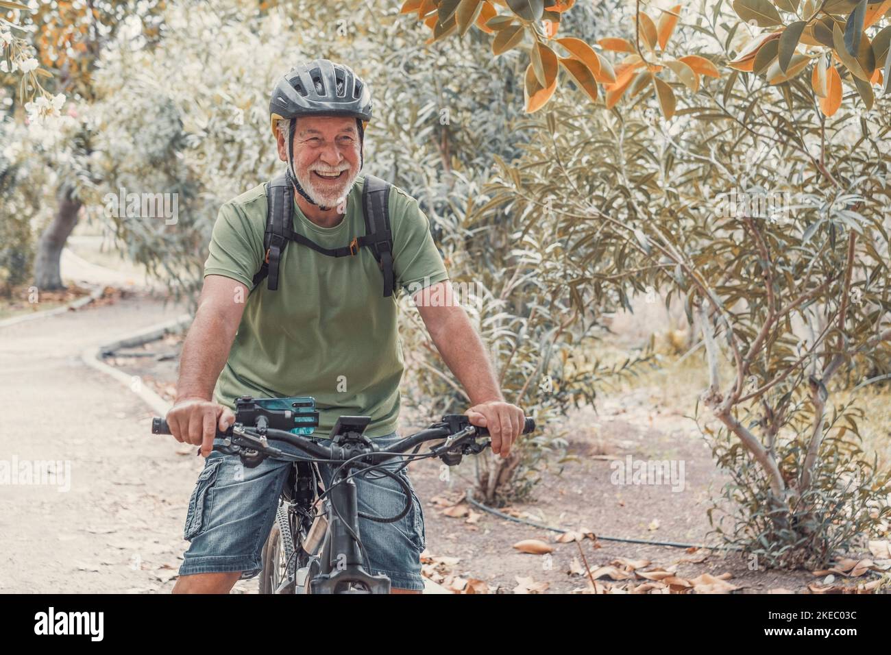 Un vecchio uomo maturo in bicicletta e godersi la natura all'aperto divertendosi. Anziani con uno stile di vita sano e in forma. Foto Stock